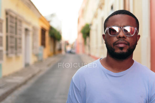 Ritratto di elegante uomo afroamericano che cammina con occhiali da sole all'aperto. Uomo nero alla moda nella strada. — Foto stock