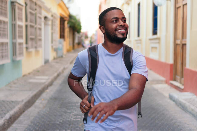 Uomo afroamericano che trasporta lo zaino mentre cammina in città — Foto stock