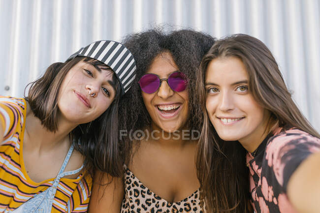 Tre belle giovani donne di razze diverse con le loro lunghe tavole da tavolo divertirsi e guardando la fotocamera — Foto stock
