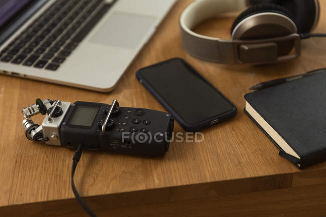 De dessus de l'enregistreur audio et écouteurs placés sur une table en bois avec ordinateur portable et ordinateur portable pour enregistrer podcast à la maison — Photo de stock