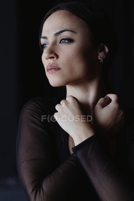 Jovem graciosa mulher de uso preto dançando flamenco e olhando para longe — Fotografia de Stock