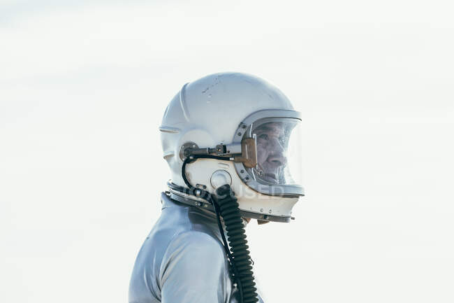 Seitenansicht des Mannes in Raumanzug und Helm, der an sonnigen Tagen in der Natur auf dem Weg steht und wegschaut — Stockfoto
