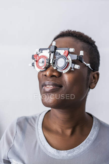Черная женщина в шкафу оптометрии во время изучения зрения — стоковое фото
