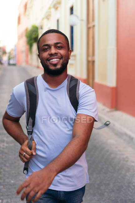 Uomo africano che trasporta lo zaino mentre cammina in città — Foto stock