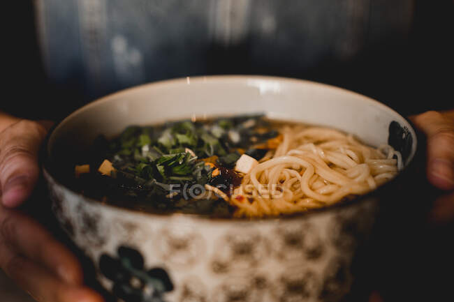 Китайський рамінний обід у керамічній мисці зі східним орнаментом на чорному тлі. — стокове фото