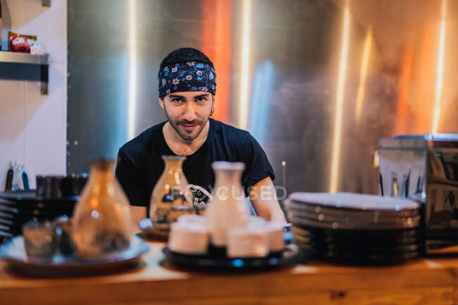 Chef in black uniform and bandana cooking Asian dish called ramen in modern cafe — Stock Photo