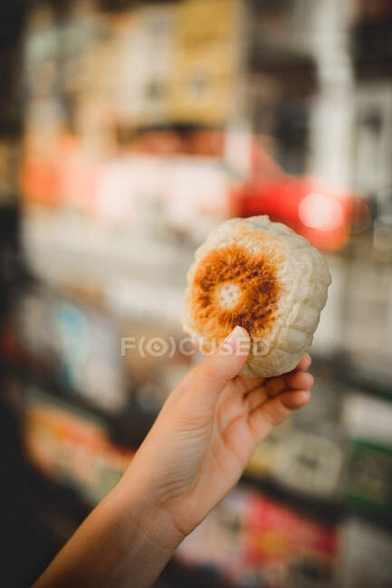 Hands of middle aged holding steamed baozi against blurred background — Stock Photo