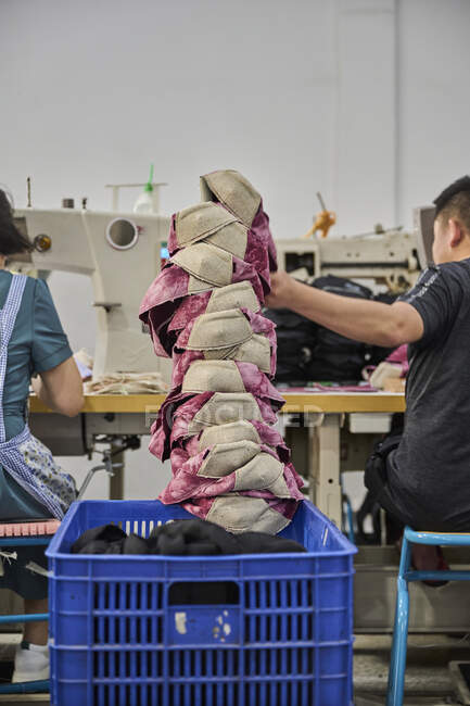 Detalle del trabajador haciendo su tarea en la fábrica de zapatos chinos - foto de stock