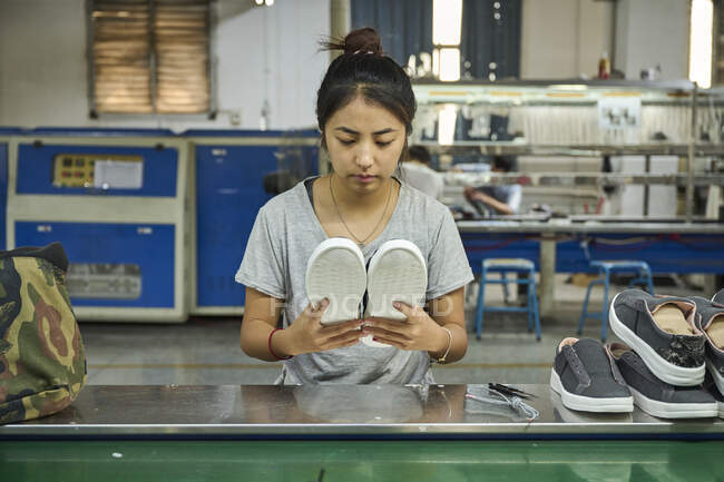Employé faisant le contrôle de qualité dans l'usine chinoise de chaussures — Photo de stock