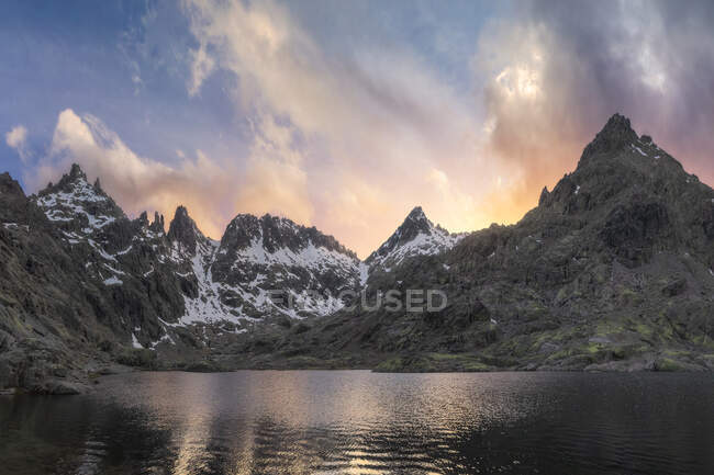 Spectacular landscape of snow capped mountains at sunset reflected on a lake — Stock Photo