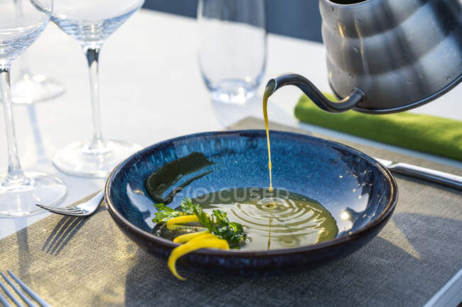 Serveur versant soupe aux lentilles au restaurant de haute cuisine en plein air — Photo de stock