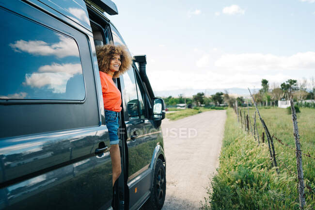 Optimistische schwarze Frau steht im Wohnmobil — Stockfoto