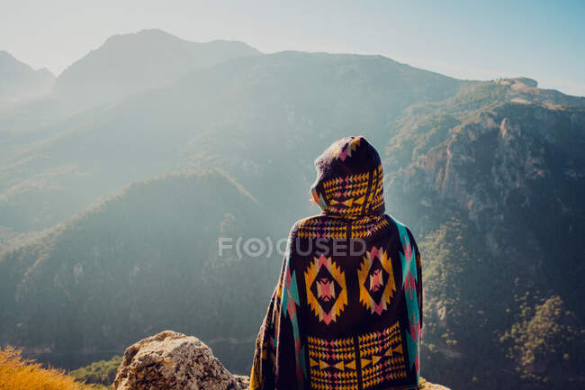 Vista posterior de una exploradora despreocupada irreconocible parada en las tierras altas y disfrutando de la libertad - foto de stock