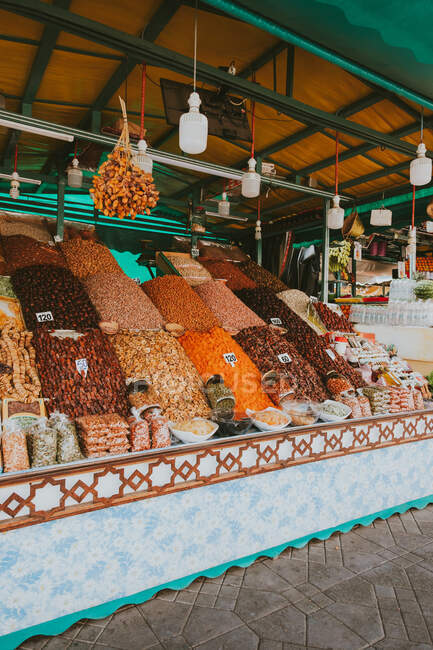 Variedad de frutos secos dispuestos en puestos ornamentales en el mercado callejero de Marrakech, Marruecos - foto de stock