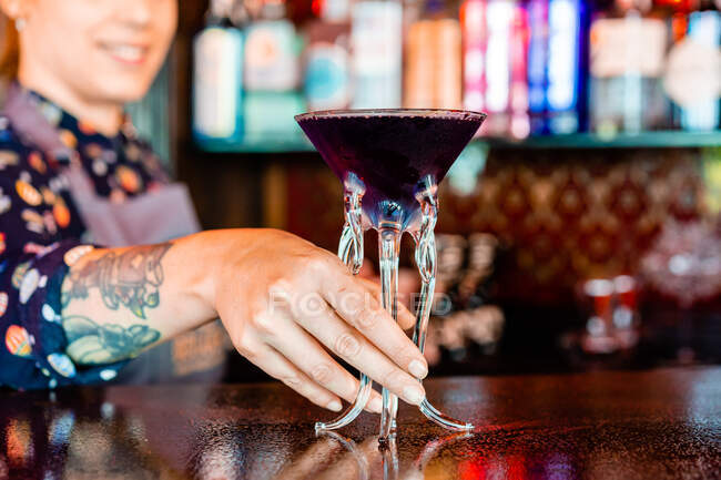 Barman souriante anonyme debout au comptoir du bar avec un type de boisson alcoolisée servie dans des verres à cocktail créatifs en forme de méduses — Photo de stock