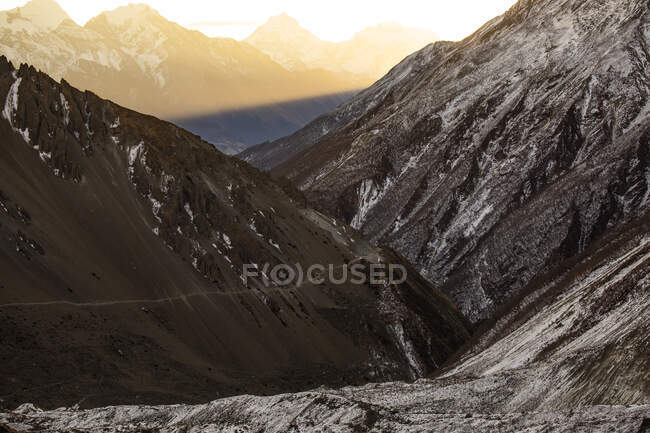 Felsige Himalaya-Berge in Nepal mit Schnee bedeckt und hell-orangefarbenem Sonnenuntergangslicht — Stockfoto