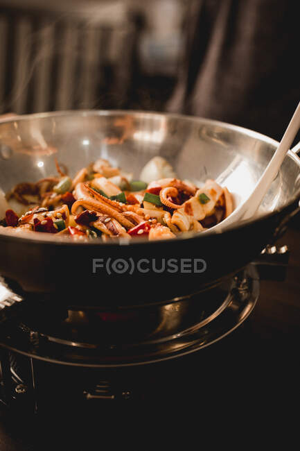 Sabroso calamar picante con verduras saludables en un tazón en la cocina del restaurante asiático - foto de stock