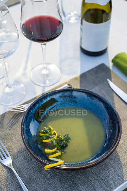 Delicious and well garnished lentil soup paired with red wine at outdoor high cuisine restaurant — Stock Photo
