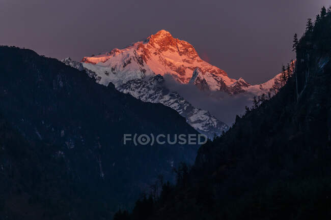 Felsige Himalaya-Berge mit Schnee bedeckt und von leuchtend orangefarbenem Sonnenuntergangslicht in Nepal beleuchtet — Stockfoto