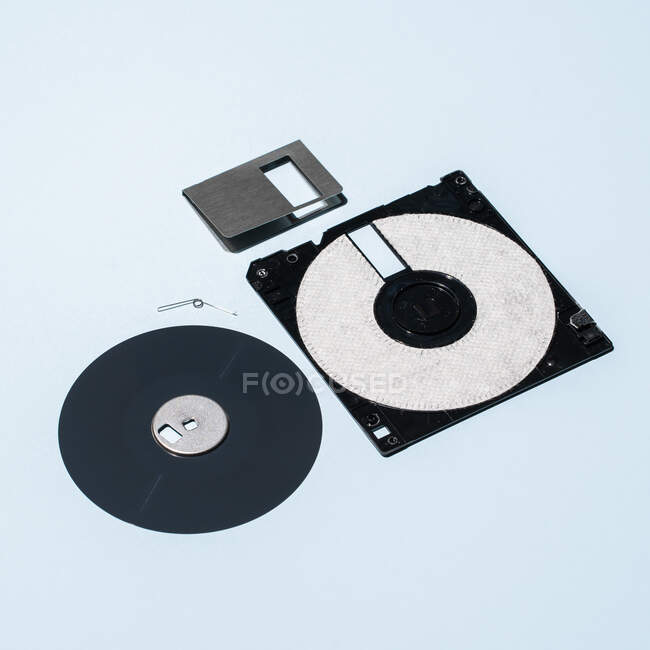 High angle of parts of old fashioned floppy disk arranged on blue background — Stock Photo
