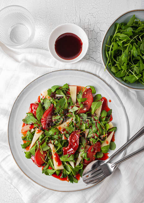 Draufsicht auf köstlichen Salat mit Rucola und Quitte auf Teller mit Soße auf Tisch — Stockfoto