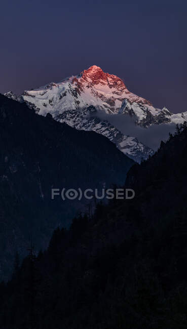 Скалистые Гималаи, покрытые снегом, освещенные ярким оранжевым солнечным светом в Непале — стоковое фото