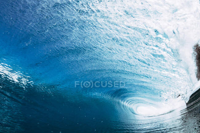 Мощные пенные морские волны катятся и брызгают по поверхности воды на фоне голубого неба — стоковое фото