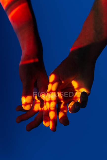Artistic image of couple hands showing love under projector lights — Stock Photo
