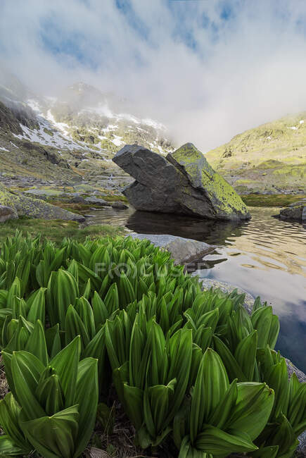 Espectacular paisaje de montañas cubiertas de nieve al atardecer reflejado en un lago - foto de stock