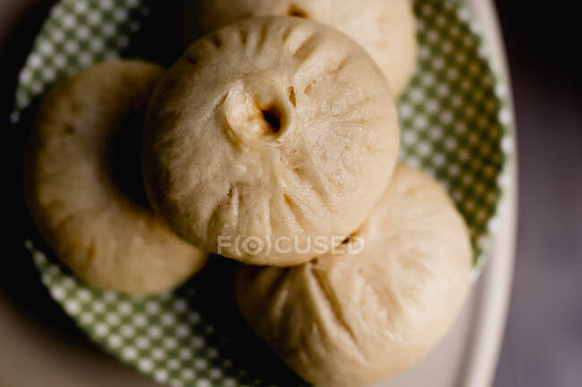From above appetizing steamed baozi bun portion placed on checked plate — Stock Photo