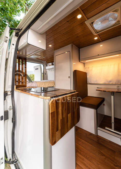 Interior contemporâneo da cozinha com móveis de madeira em campista de viagem estacionado na natureza — Fotografia de Stock