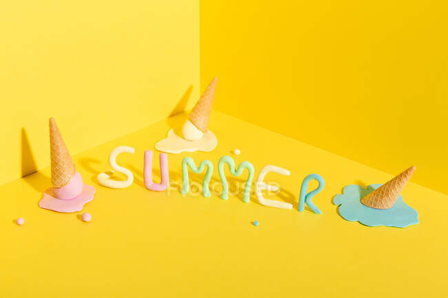 De cima de cones de waffle mockup com sorvete colorido derretido colocado no fundo amarelo com inscrição Verão — Fotografia de Stock