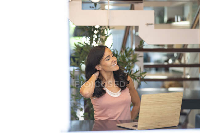 Mujer freelancer feliz sentado en la mesa en casa y la tableta de navegación mientras se trabaja en el proyecto de negocios - foto de stock