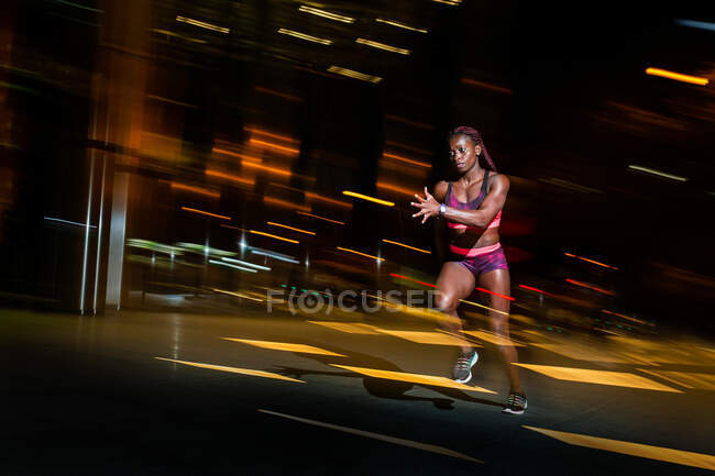 Mulher atlética correndo na rua turva — Fotografia de Stock