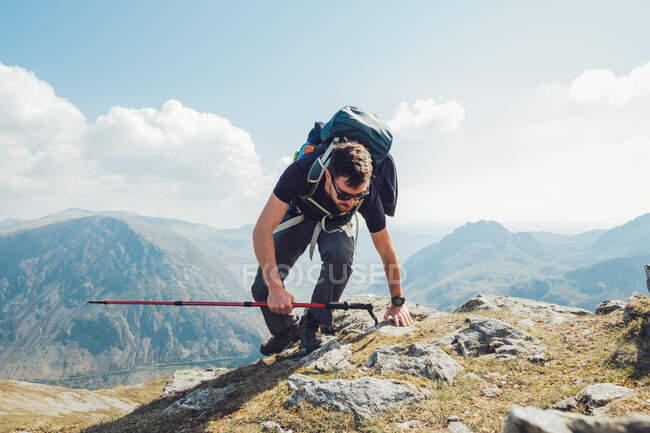 Viajando homem caminhando em montanhas com poste de trekking durante as férias no verão em Gales — Fotografia de Stock