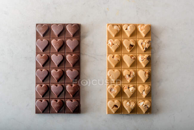 Top view of delicious chocolate candies with nuts in shape of heart on white background — Stock Photo
