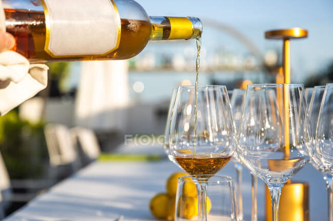 Официант, пирующий вино в стакане в ресторане высокой кухни на открытом воздухе — стоковое фото
