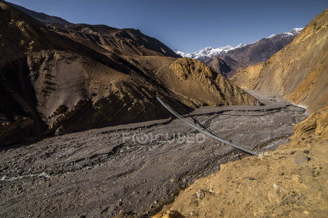 Paisagem de tirar o fôlego de metal suspensão passarela sobre o rio no Himalaia no dia ensolarado no Nepal — Fotografia de Stock