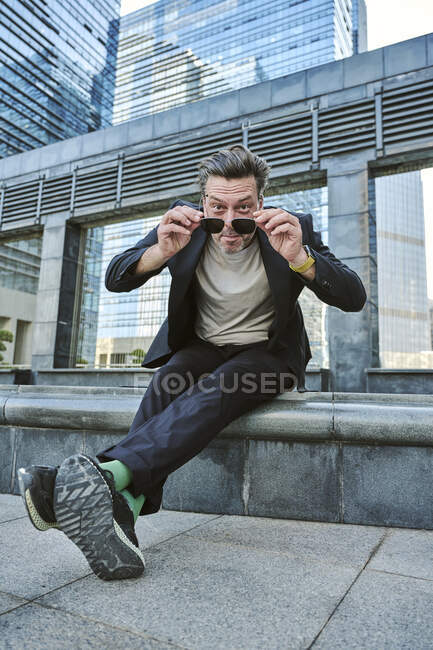 Designer sitting outside of the office's building having rest and smiling — Stock Photo