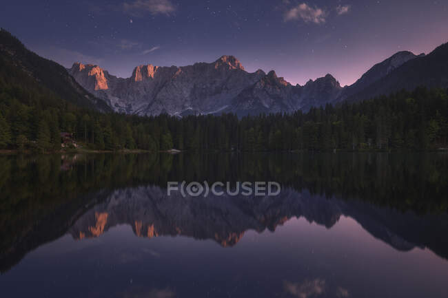 Herrliche Landschaft mit ruhigem Teich, umgeben von Bergen unter Sonnenuntergang in Slowenien — Stockfoto