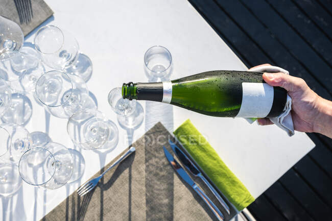 Garçom que serve champanhe em um copo no restaurante de alta cozinha ao ar livre — Fotografia de Stock