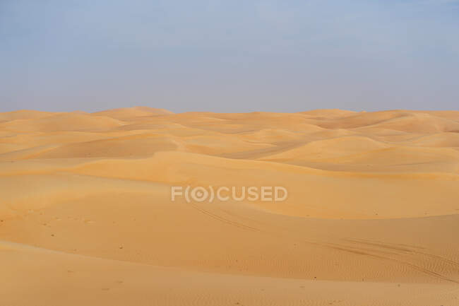 Paesaggio desertico minimalista con dune sabbiose e cielo azzurro negli Emirati — Foto stock