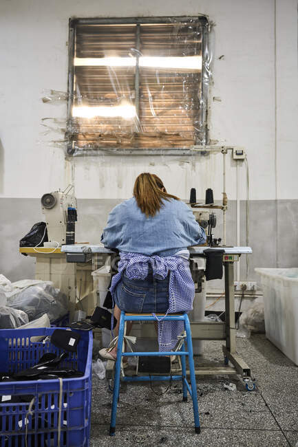 Деталь рабочего, занимающегося шитьем на китайской обувной фабрике — стоковое фото