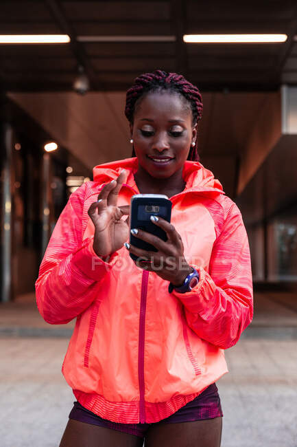 Deportiva usando smartphone en la calle - foto de stock