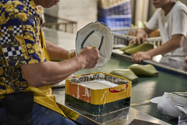 Роботодавець виконує своє завдання на виробничій лінії взуття на китайській фабриці взуття. — стокове фото