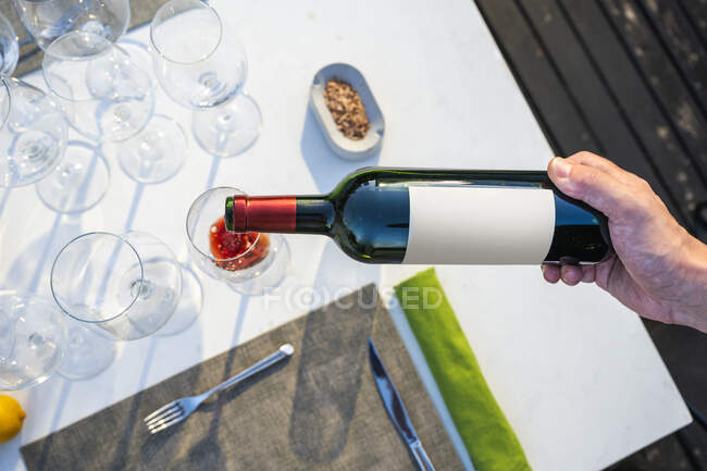 Waiter pouring red wine in a glass at outdoor high cuisine restaurant — Stock Photo