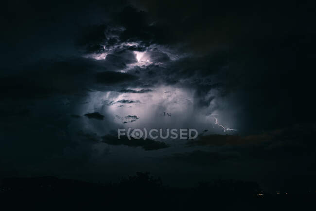 Cielo tempestoso di fulmini tra le nuvole scure e drammatiche — Foto stock