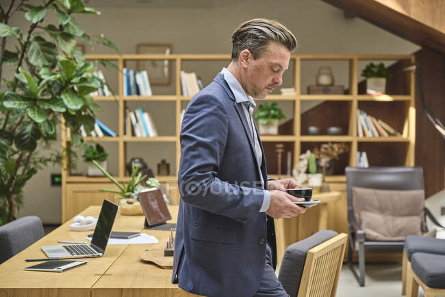 Designer assis sur son bureau prendre un café pendant le temps de travail — Photo de stock
