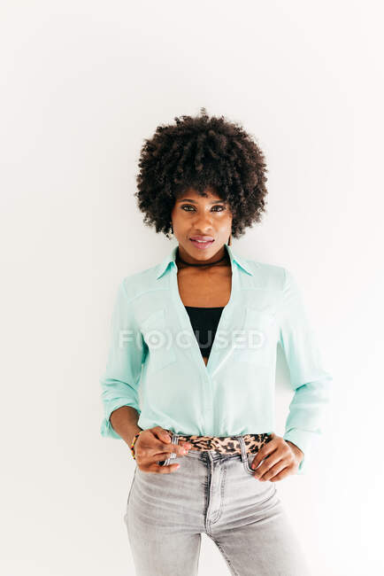 Jeune jolie femme afro-américaine avec de beaux cheveux afro en tenue tendance sur fond blanc — Photo de stock