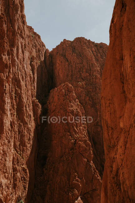 Acantilados rocosos ásperos que rodean el estrecho barranco en un día soleado cerca de Marrakech, Marruecos - foto de stock